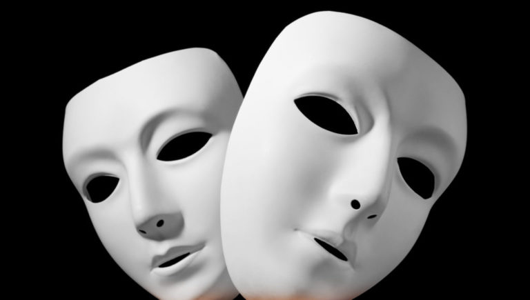 Dwie białe maski teatralne na czarnym tle