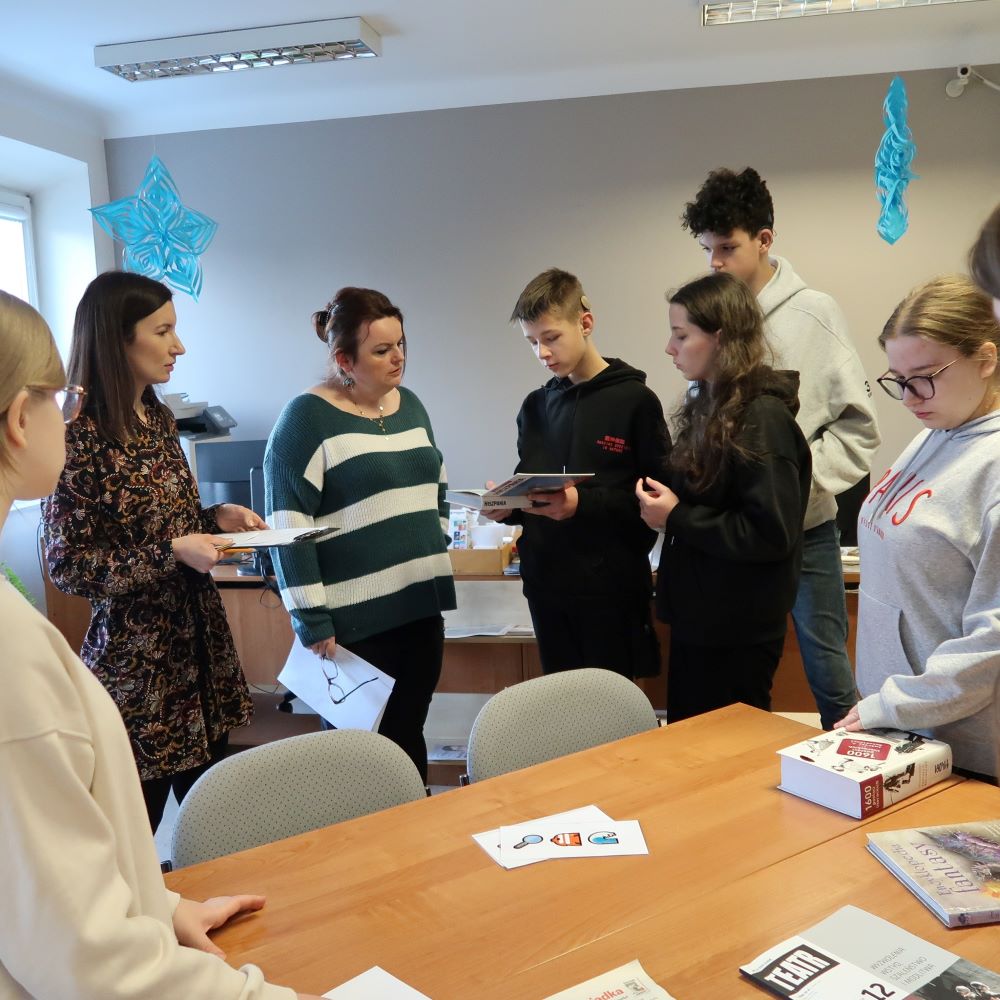 Grupa ludzi stojących wokół stołu.