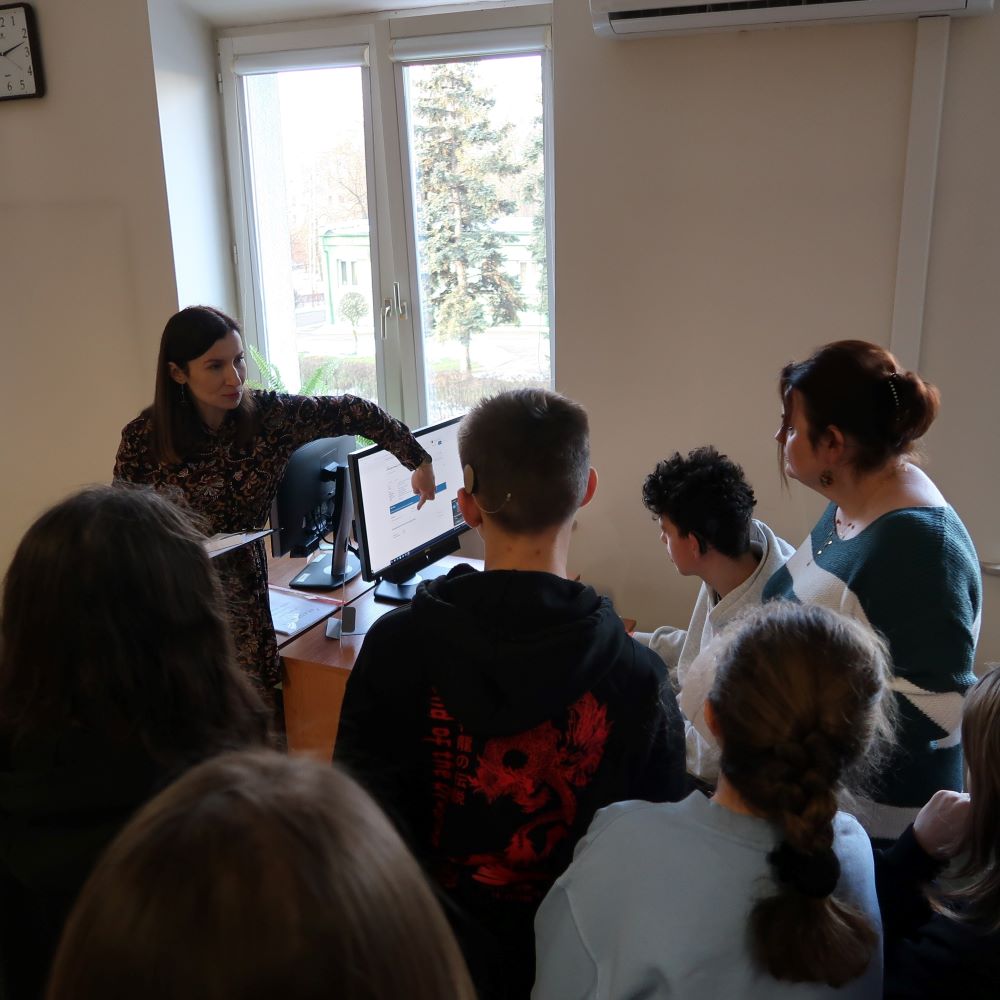 Kobieta stoi przed grupą ludzi.