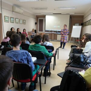 miedzynarodowy-dzien-jezyka-ojczystego-psp-24-5 Uczniowie siedząc słuchają prowadzącej zajęcia