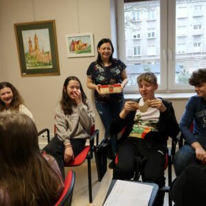 obchodody-Międzynarodowego-Dnia-Jezyka-Ojczystego-uczniowie-PSP im. Jana-Kochanowskiego-w-Zakrzewie-3 Uczeń siedząc odczytuje tekst kalamburów zapisanych na kartce.