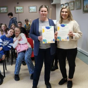 obchodody-Międzynarodowego-Dnia-Jezyka-Ojczystego-uczniowie-PSP im. Jana-Kochanowskiego-w-Zakrzewie-7 Dwie Panie pozują do zdjęcia trzymając w rękach albumy okolicznościowe z okazji Międzynarodowego Dnia Języka Ojczystego.