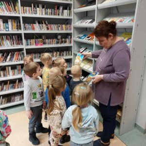 Grupa dzieci ogląda okładki filmów na płycie DVD