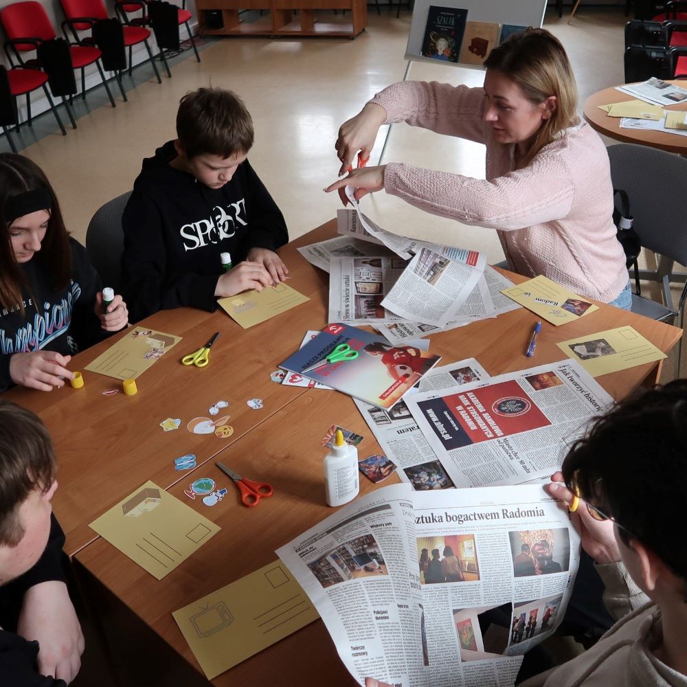 rok-wieslawy-szyborskiej-4 Uczniowie siedzący przy stole wykonują pocztówki