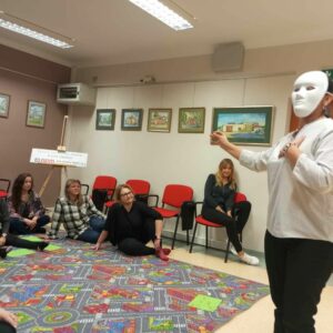 Kobieta w masce na twarzy odgrywa scenę.