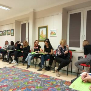 Siedzące kobiety na krzesłach robą rysunki