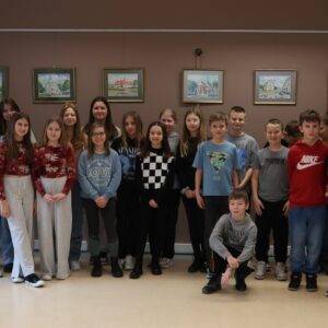 Grupy chłopców i dziewczynek pozujące do zdjęcia w sali wystawowej Biblioteki Pedagogicznej w Radomiu