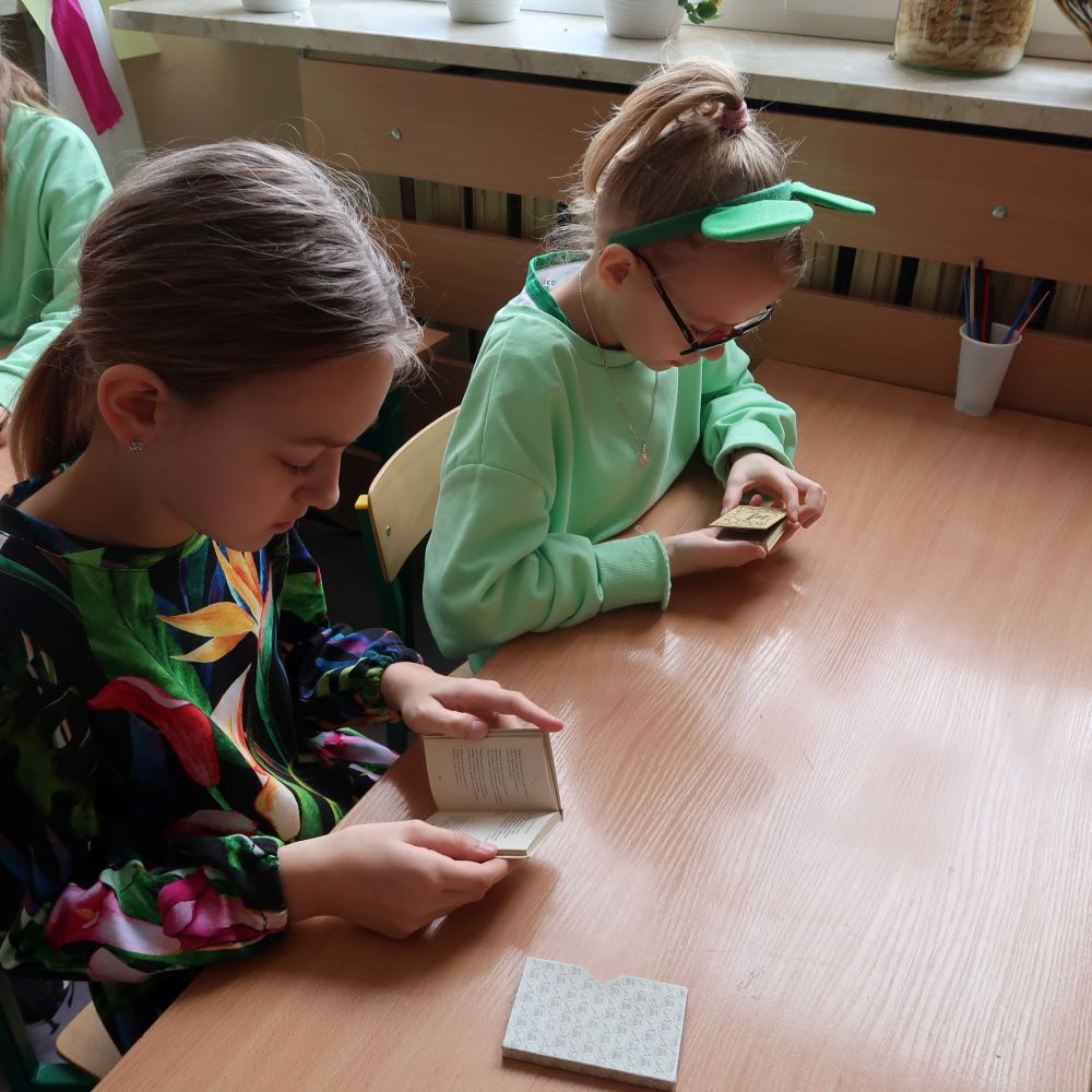 Dwie dziewczynki czytają miniaturowe książeczki