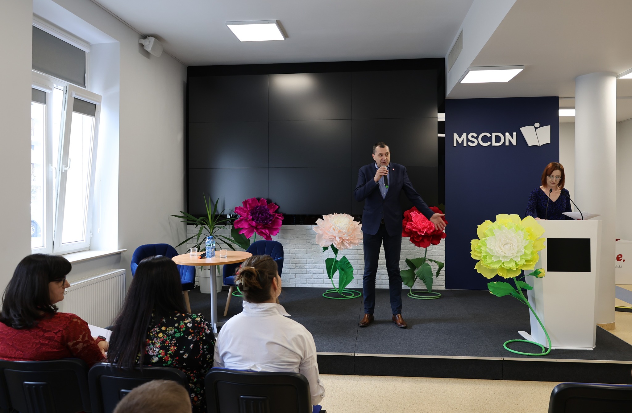 konkurs-tworczosc-literacka-2 Mężczyzna z mikrofonem w ręce przemawia do zebranych na sali