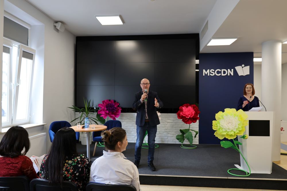 konkurs-tworczosc-literacka-3 Łysy mężczyzna z mikrofonem w ręce przemawia do zebranych na sali