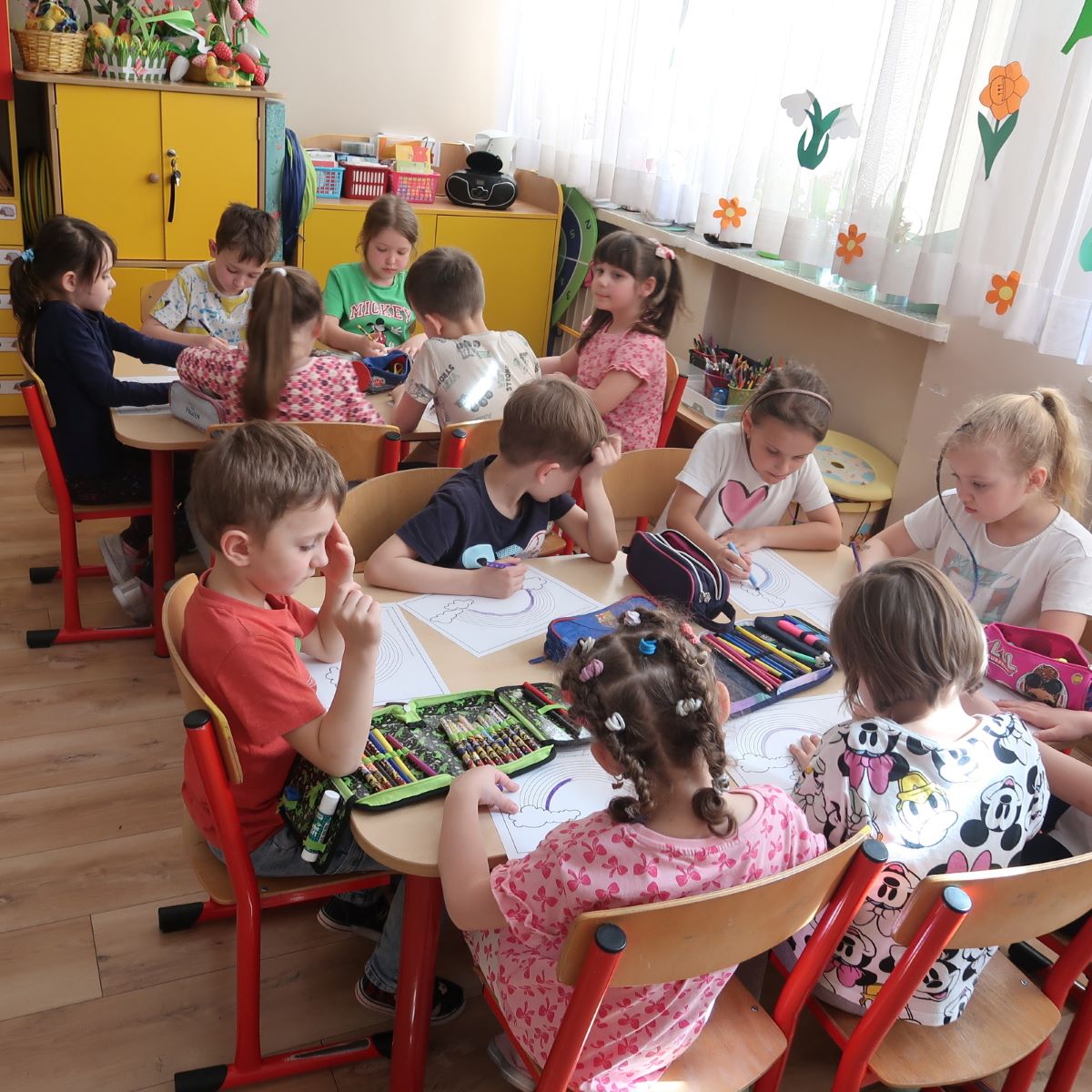 dzien-teczy-3 Dzieci kolorują kolorowanki siedząc przy stoliku