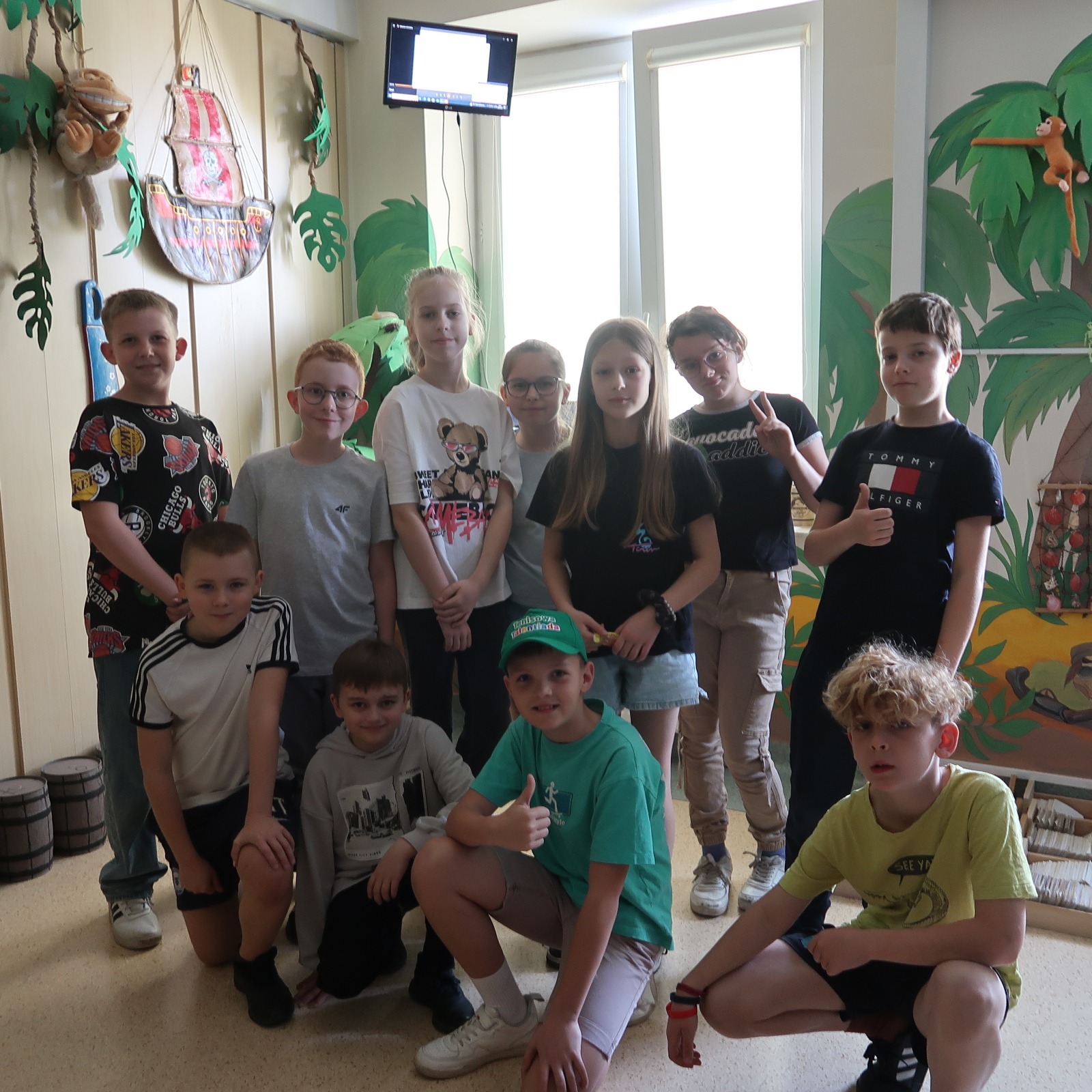 Grupa uczniów pozuje do zdjęcia pamiątkowego w sali escape room biblioteki