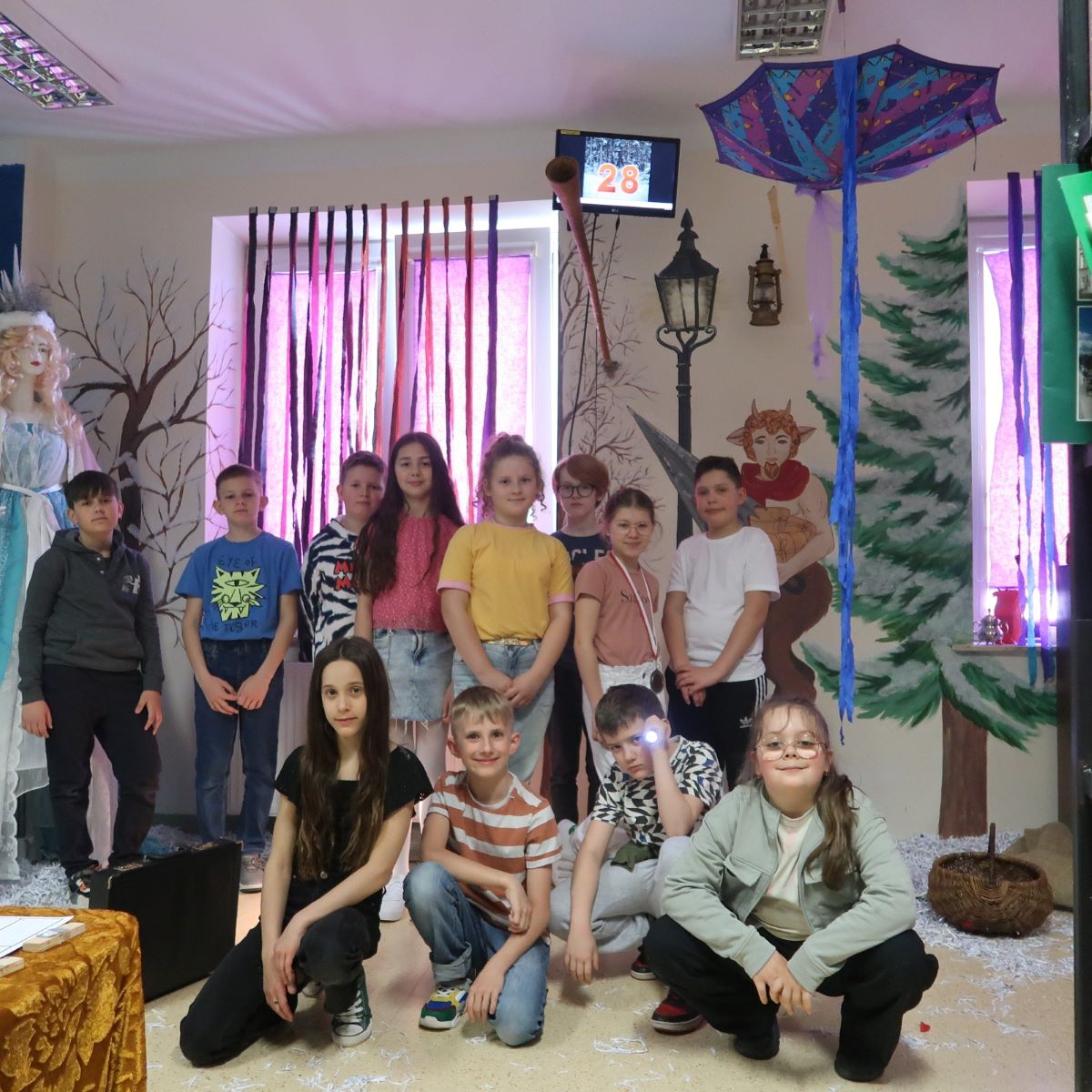 Grupa uczniów pozuje do zdjęcia pamiątkowego w sali escape roomie biblioteki