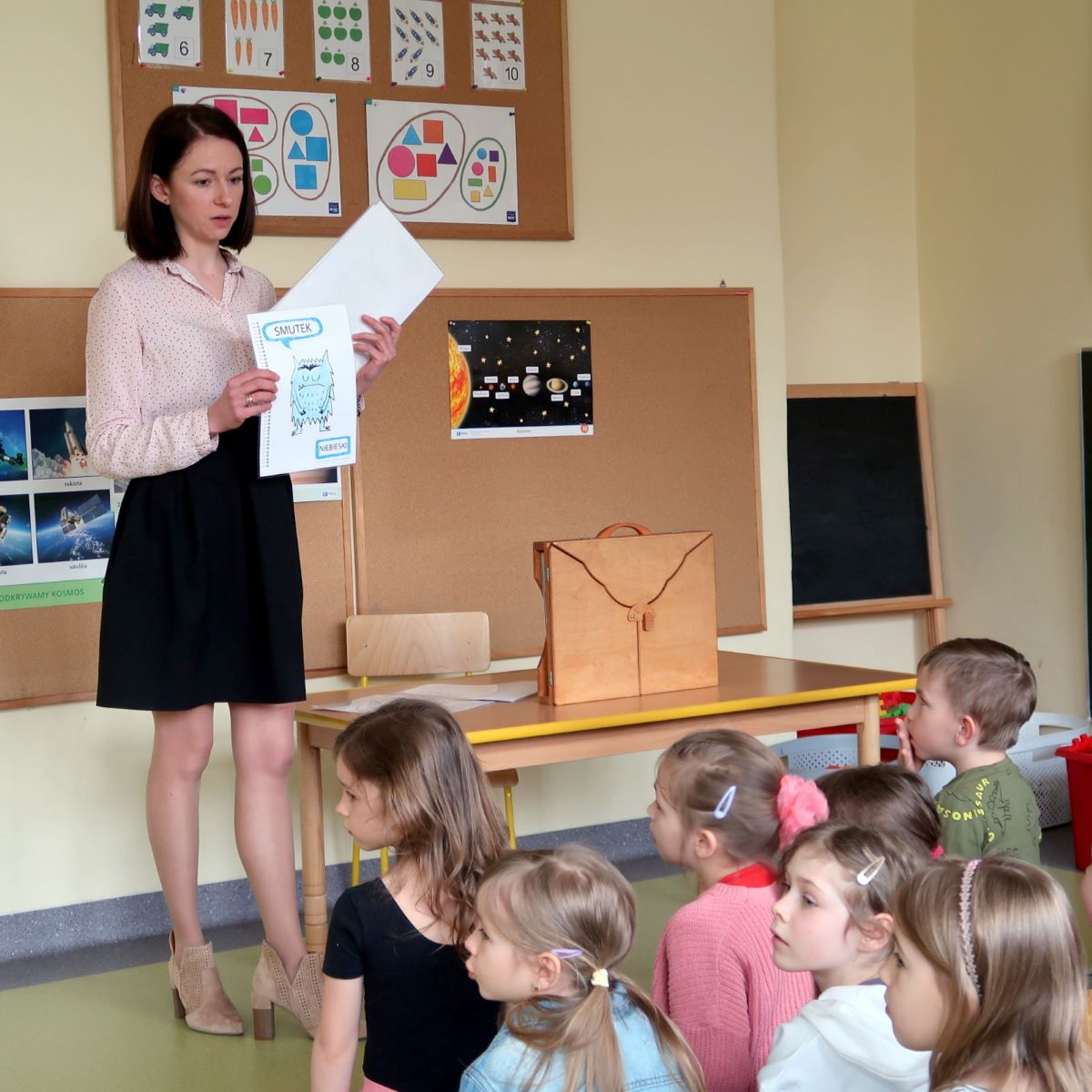 kolorowy-potwor-1 Prowadząca zajęcia pokazuje dzieciom kartki z rysunkami symbolizującymi emocje