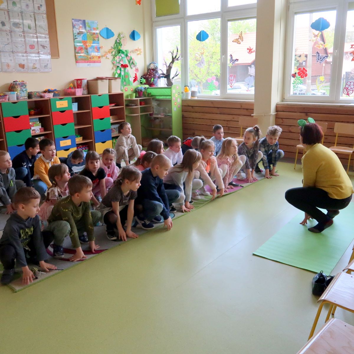 kolorowy-potwor-3 Dzieci powtarzają ćwiczenia gimnastyczne prezentowane przez prowadzącą zajęcia