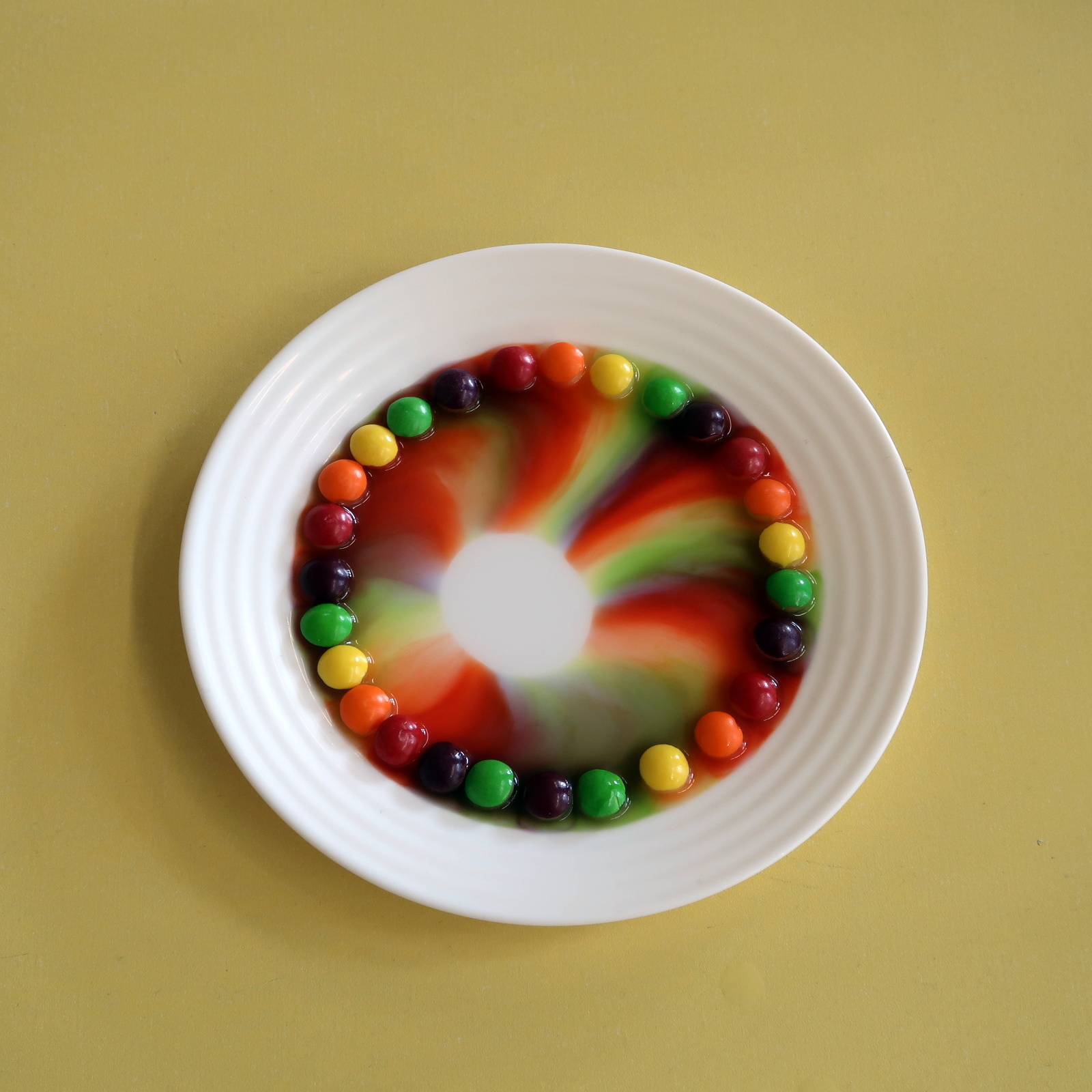 talerzyk z kolorowymi kulkami rozmywającymi się we wszystkie kolory tęczy