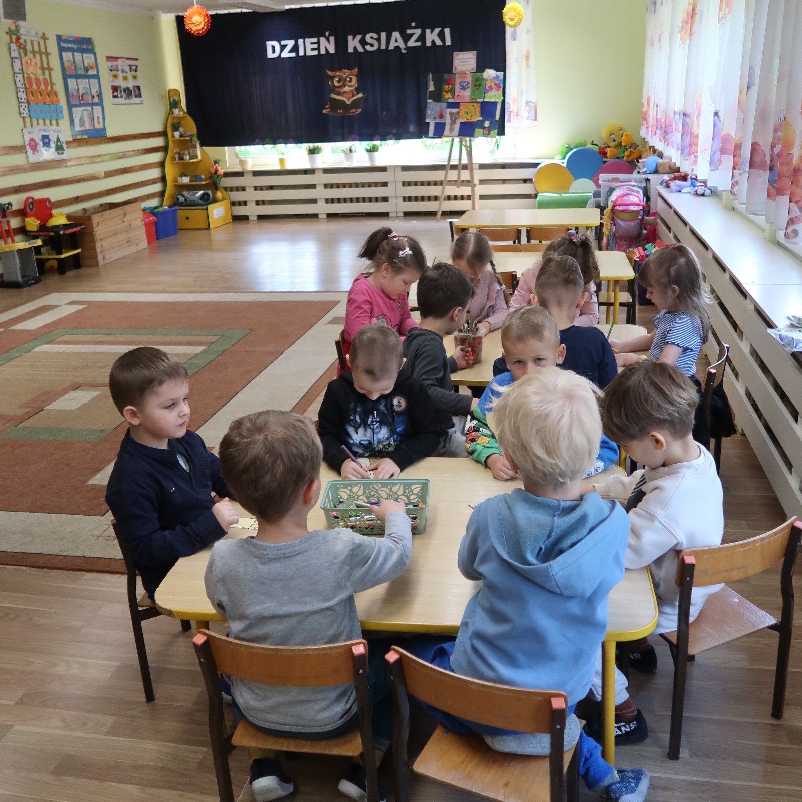 zajecia-PSP-12-4 Grupa dzieci wykonuje zakładki do książek siedząc przy stoliku