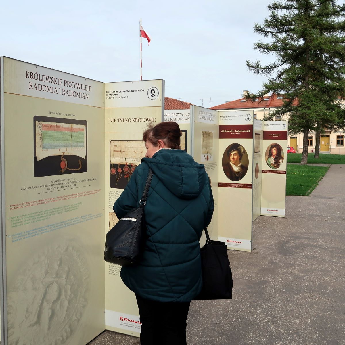 zwiedzanie-radomia-4 Kobieta wczytuje się w tekst tablic pamiątkowych ustawionych na ulicy
