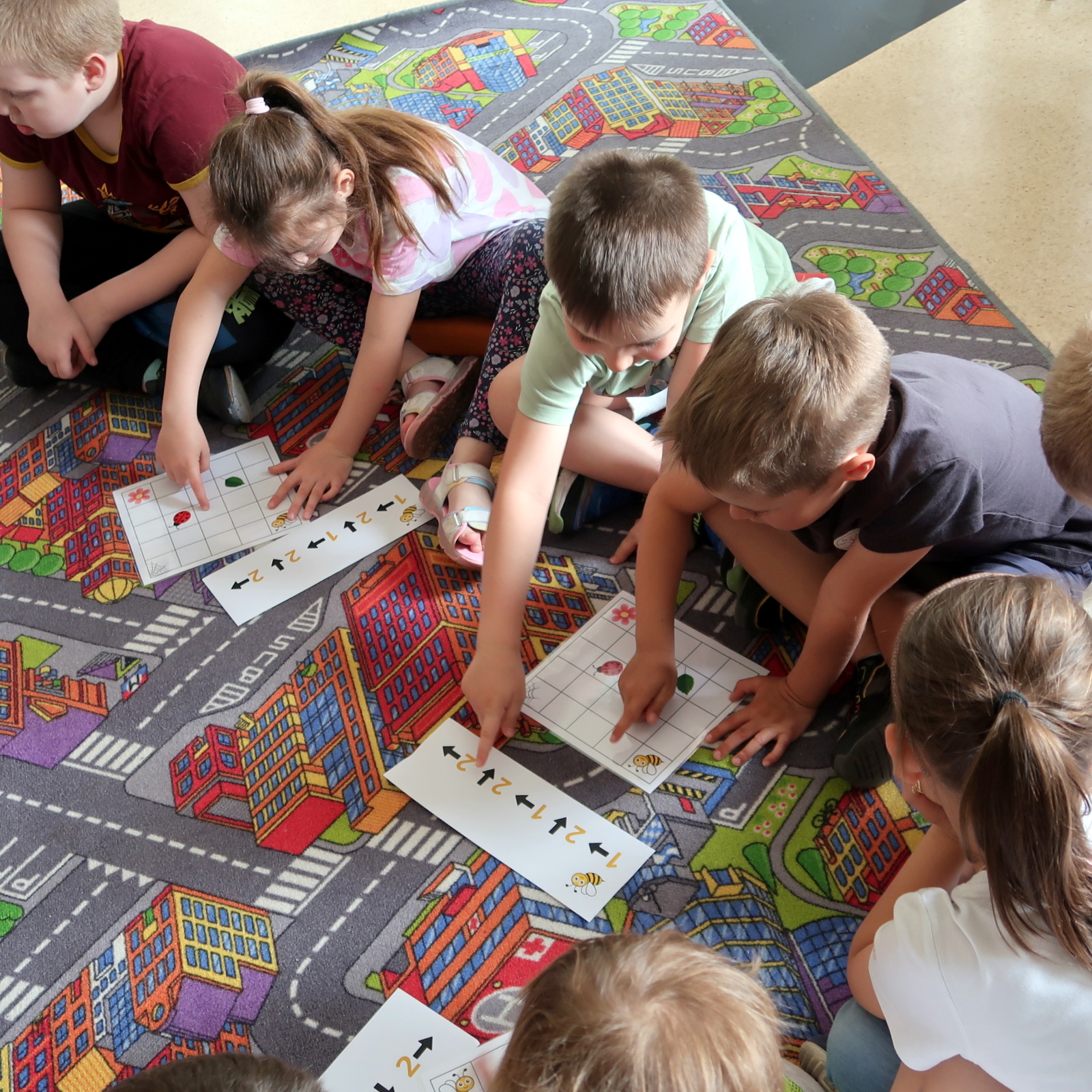 IMG_4458 Dzieci siedząc na dywanie rozwiązują zagadki logiczne o tematyce pszczół