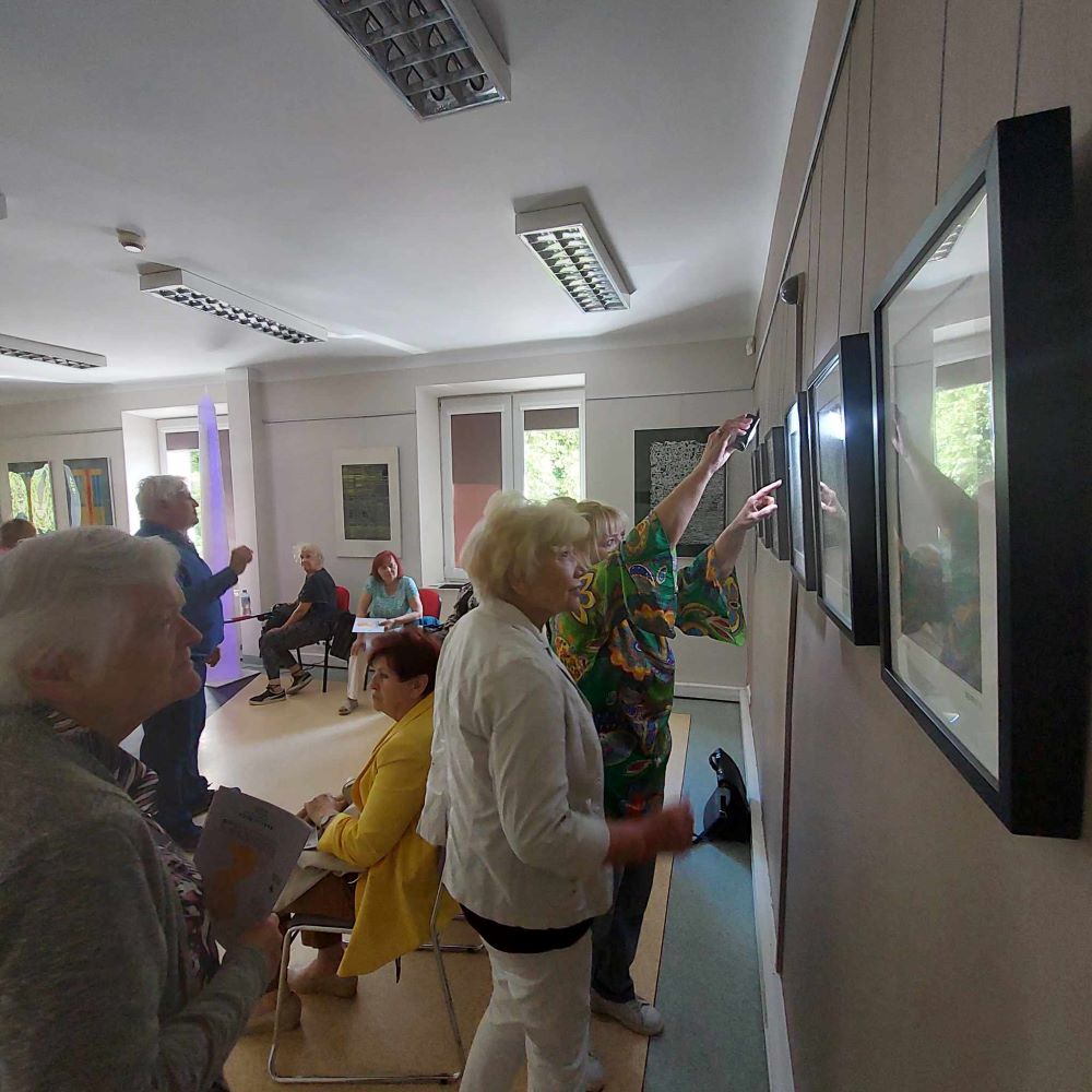 Uczestnicy Uniwersytetu Trzeciego Wieku oglądają wystawę prac plastycznych
