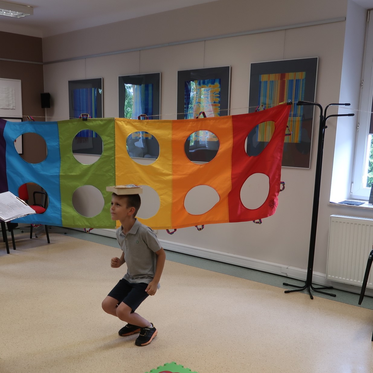 Chłopiec próbuje donieść niesioną na głowie książkę