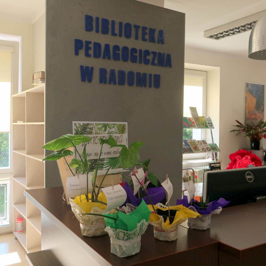 Ekspozycja kwiatów doniczkowych na tle napisu Biblioteka Pedagogiczna w Radomiu