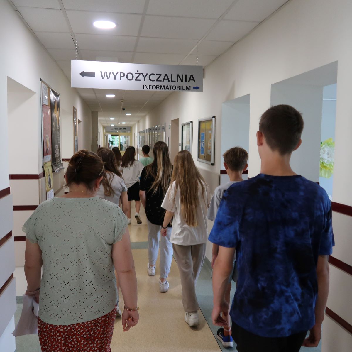 Grupa dzieci na korytarzu bibliotecznym