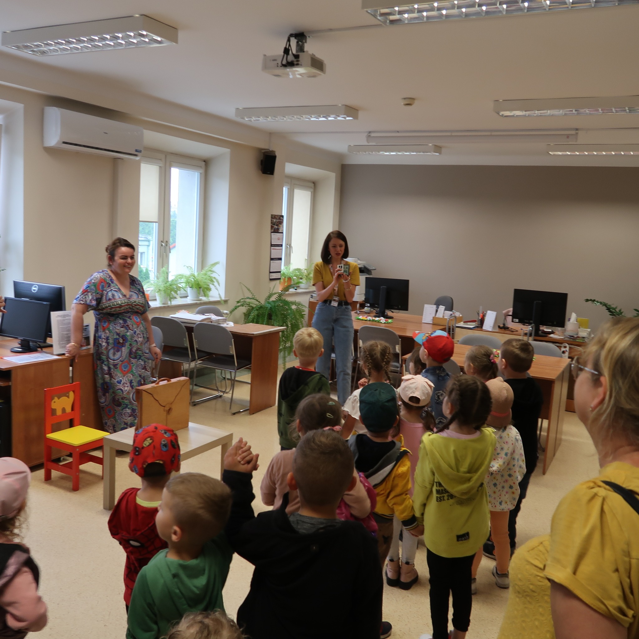 Dwie panie prezentują dzieciom teatrzyk kamishibai