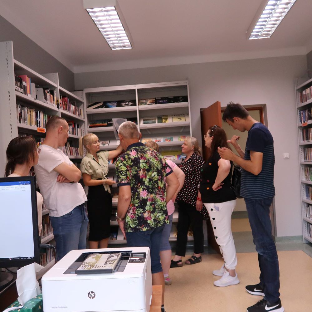 prowadząca zajęcia prezentuje uczestnikom zajęć zbiory specjalne zgromadzone w bibliotece.