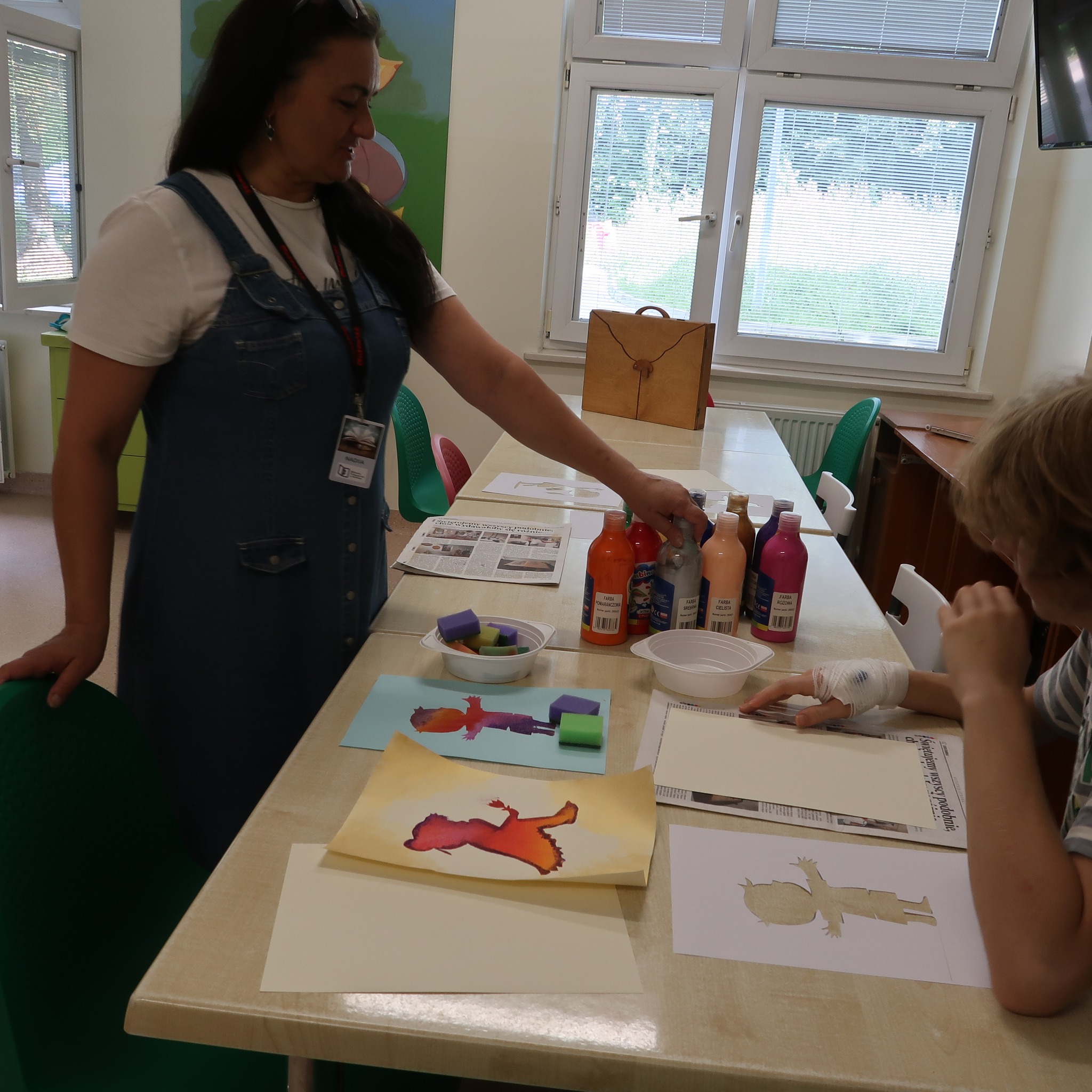 Pani prezentuje dzieciom malarskie farby