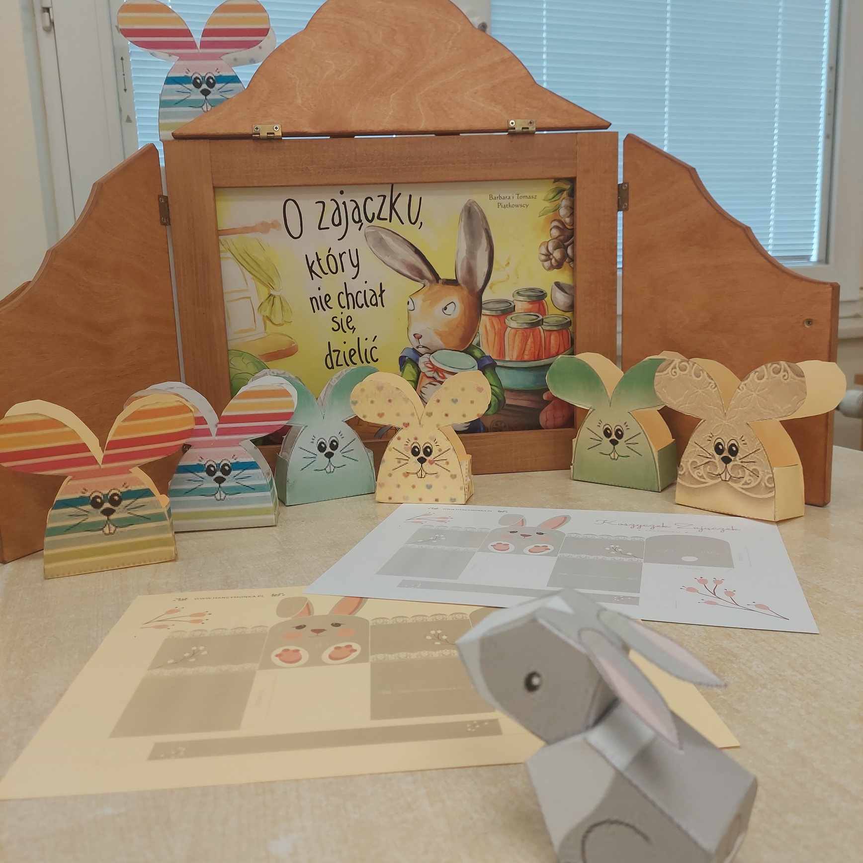 Prezentacja prac plastycznych dzieci na tle teatrzyku kamishibai.