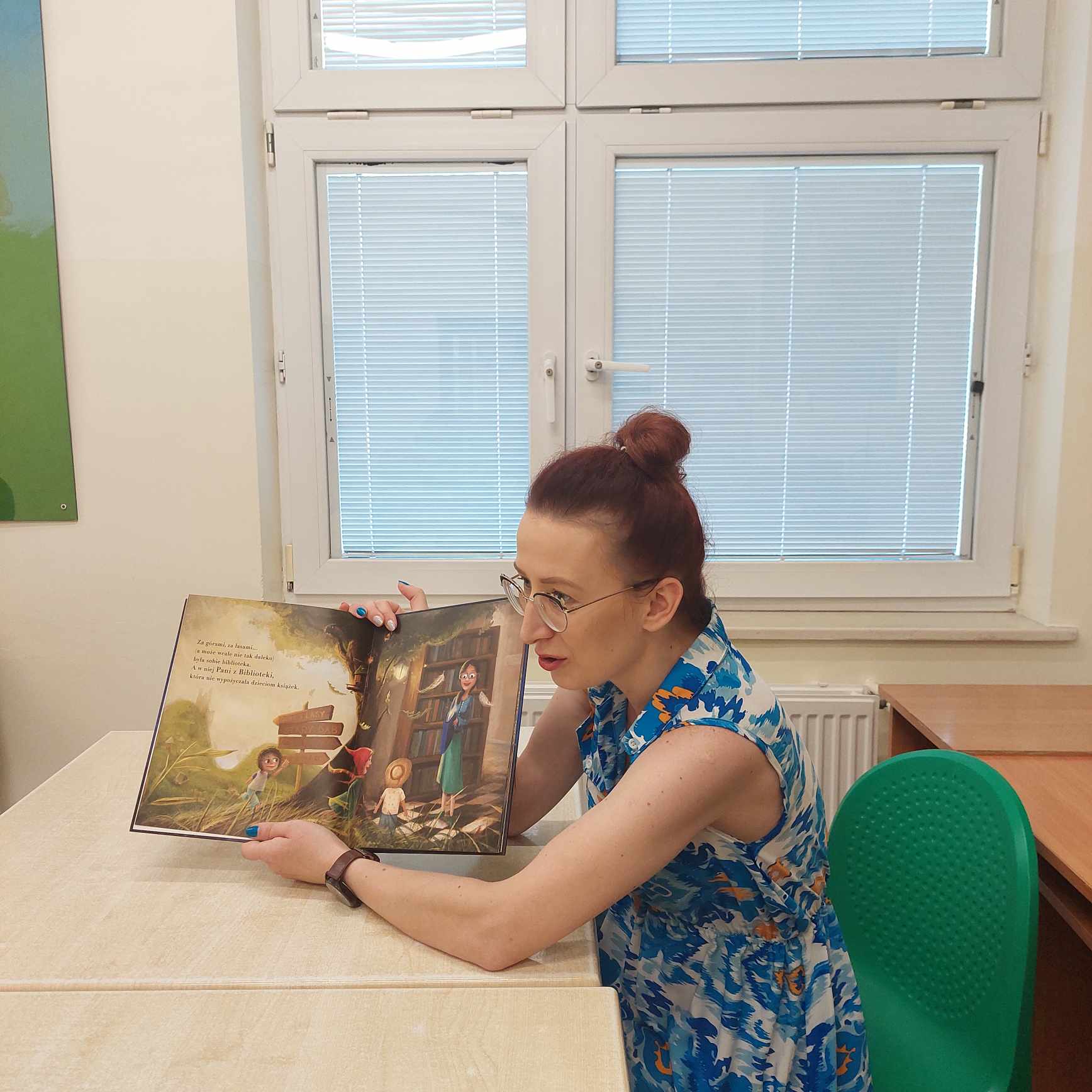 Pani pokazuje obrazki w książce .