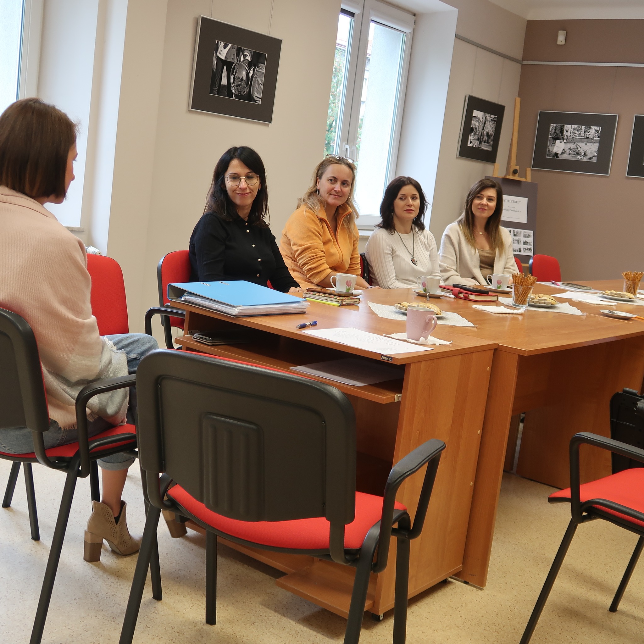 Młode bibliotekarki siedzą za stołem podczas zebrania