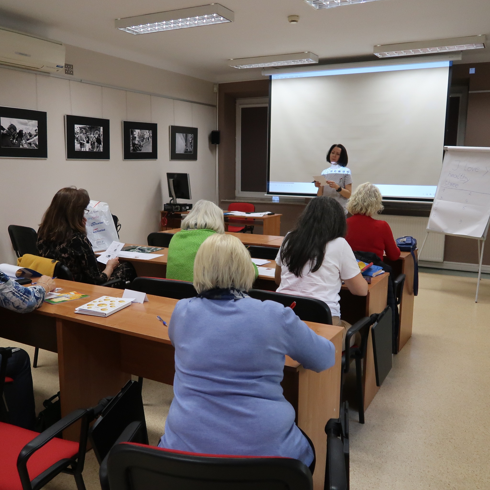 Uczestnicy zajęć z podstaw języka angielskiego uważnie słuchają tego co mówi do nich prowadząca.