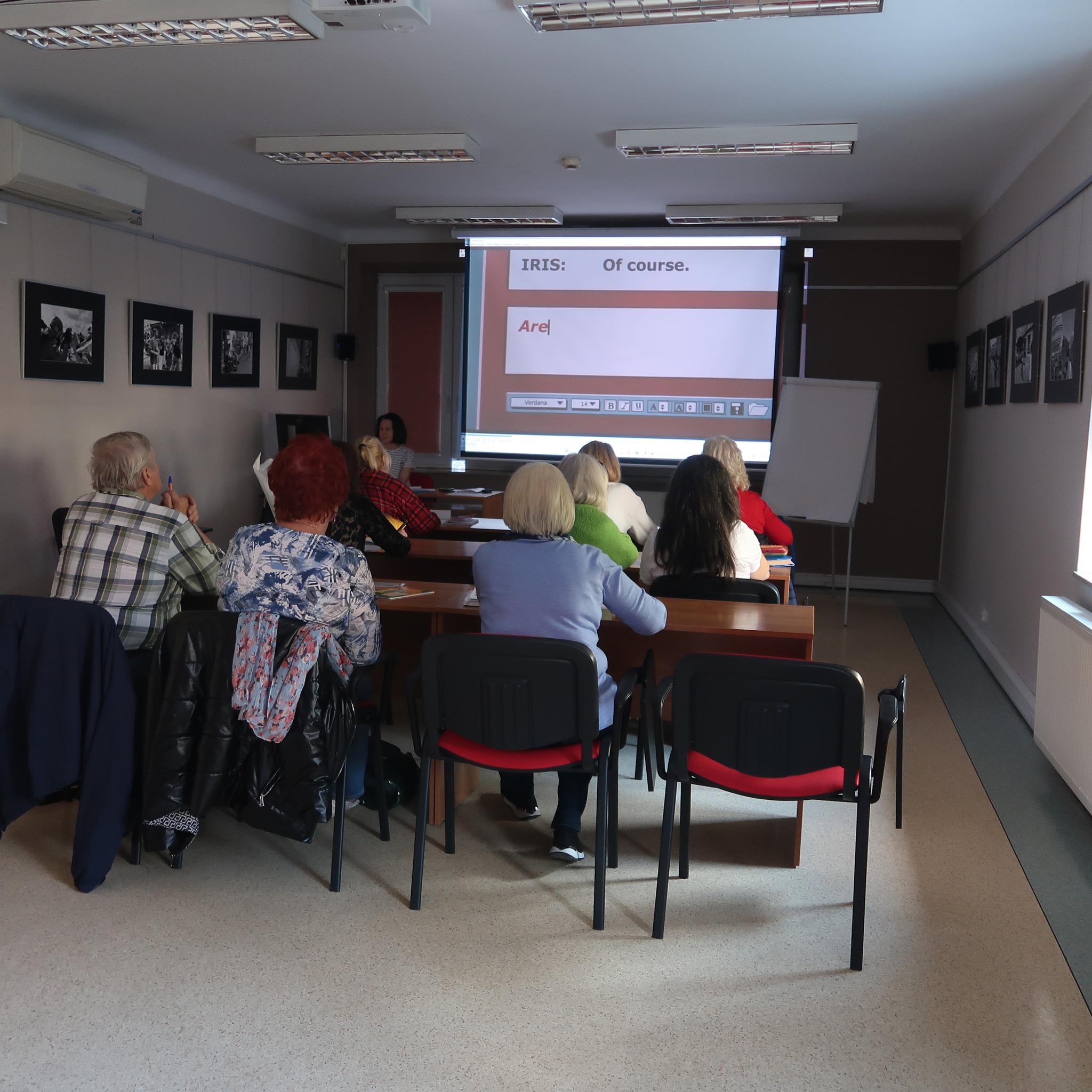 Uczestnicy zajęć z podstaw języka angielskiego uważnie słuchają tego co mówi do nich prowadząca